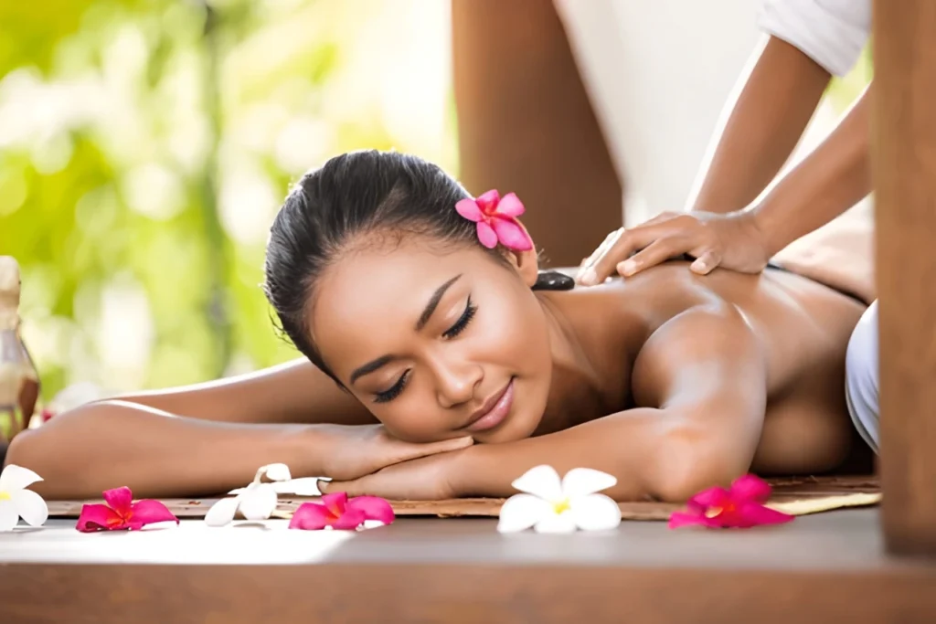 Woman relaxing during a Balinese massage surrounded by flowers at Nexus International Spa in Banashankari, Bangalore.